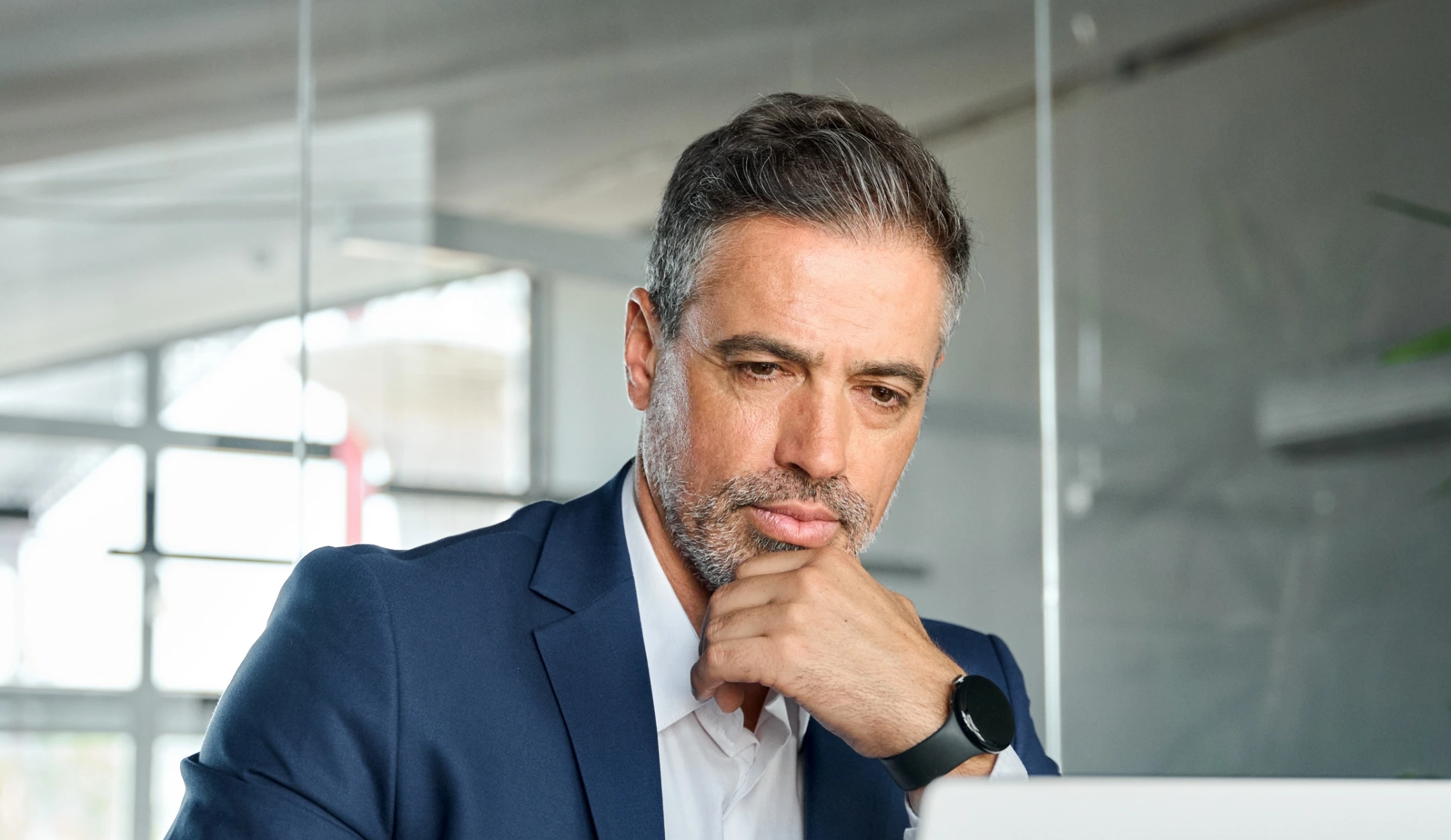 Pessoa sorrindo enquanto utiliza um notebook com expressão positiva e produtiva.